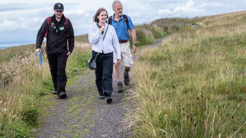 Welcome Assistant taking visitors on a guided walk on Divis Moutnain